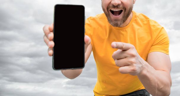 cropped view of man presenting smartphone screen with copy space. point finger. - Foto, Imagen