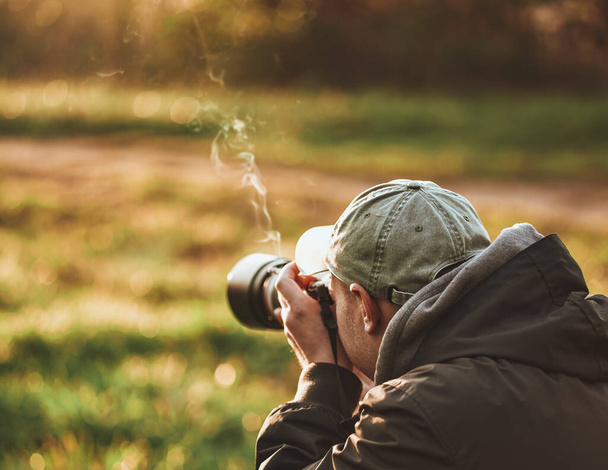 Професійний фотограф дикої природи чоловік фотографує обладнання цифрової камери птахів і тварин у природі
. - Фото, зображення