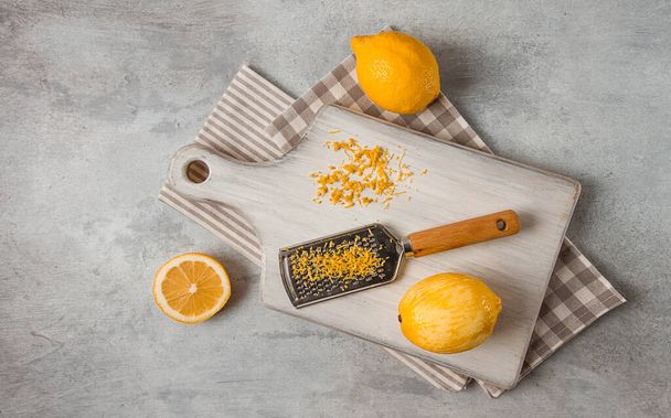 Grated lemon zest, on a cutting board, with a grater , top view, no people, - Valokuva, kuva