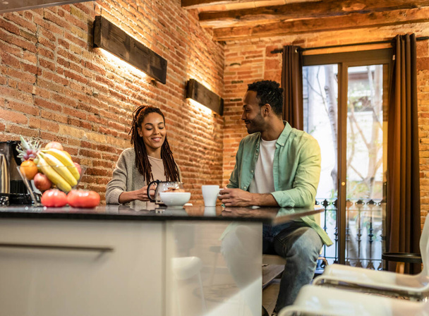 Evde kahve içen mutlu bir çift. Afrikalı Amerikalılar, modern apartmanlarında mutlular. - - Fotoğraf, Görsel