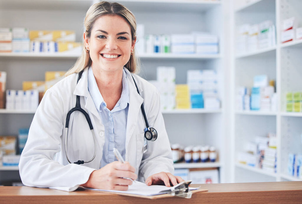 Portrait, happy or pharmacist writing a checklist of medicine inventory or healthcare stock supply on pharmacy counter. Wellness, trust or face of chemist working on store drugs paperwork with smile. - Zdjęcie, obraz