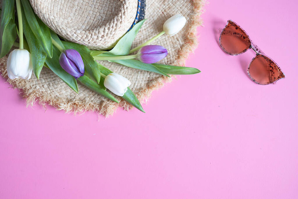 Dámské plážové doplňky: slaměný klobouk a sluneční brýle na růžovém pozadí. Jaro a léto. Byt ležel, horní pohled. - Fotografie, Obrázek