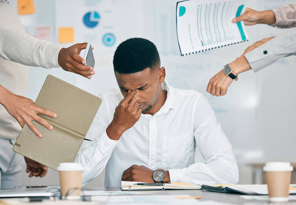 Stress, burn-out en vermoeide zwarte man met hoofdpijn, gefrustreerd of overweldigd door collega 's op het werk. Overwerkt, geestelijke gezondheid en angst van uitgeputte mannelijke werknemer multitasking aan het bureau in functie - Foto, afbeelding