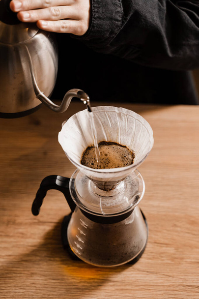 Öntsük át a szűrő kávé alternatív főzési módszer. Forró víz öntése pörkölt és őrölt kávébabra papírszűrőben - Fotó, kép