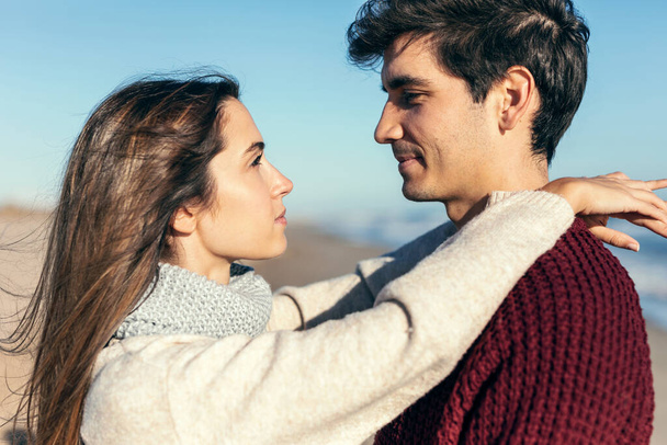 Shot of beautiful young couple in love enjoying the day in a cold winter on the beach. - Foto, Imagen