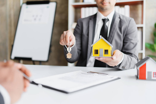 Onroerend goed bedrijf om huizen en grond te kopen zijn het leveren van sleutels en huizen aan klanten na akkoord te gaan met een huis te kopen overeenkomst en een lening af te sluiten - Foto, afbeelding