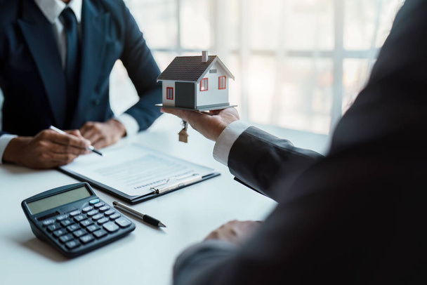 Real estate company to buy houses and land are delivering keys and houses to customers after agreeing to make a home purchase agreement and make a loan agreement - 写真・画像