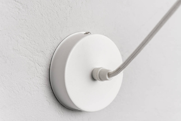 λευκό ηλεκτρικό βύσμα για ένα μενταγιόν λαμπτήρα σε γκρι φόντο, closeup - Φωτογραφία, εικόνα