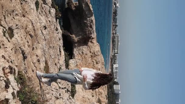 A young carefree woman is walking at the edge near sea caves love bridge in Ayia Napa, Cyprus - Footage, Video