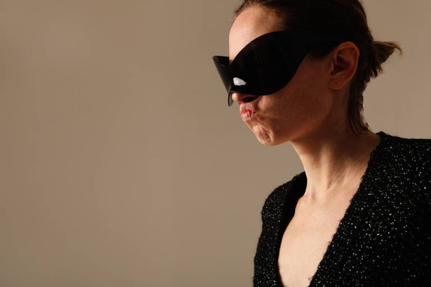 Vertical portrait of confident young woman wearing sunglasses posing indoor. High quality photo. - 写真・画像