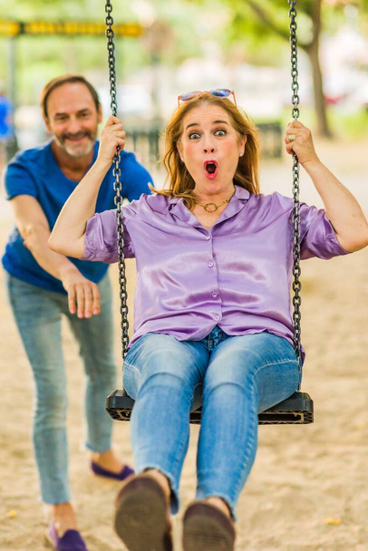 homme et femme couple d'âge mûr ensemble heureux en plein air dans une aire de jeux du parc. amour adulte européen. - Photo, image