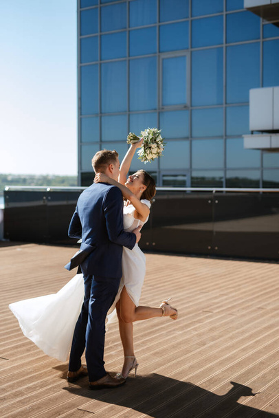 bruid en bruidegom eerste ontmoeting op het dak van een glazen wolkenkrabber - Foto, afbeelding