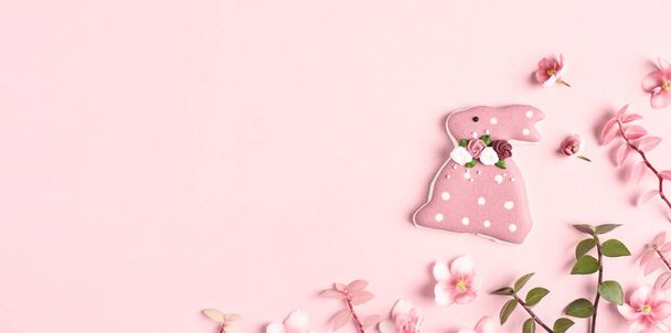 Happy Easter banner. Easter decorations, bunny, grass and flowers on pink background. Copy space, flat lay. - Photo, Image