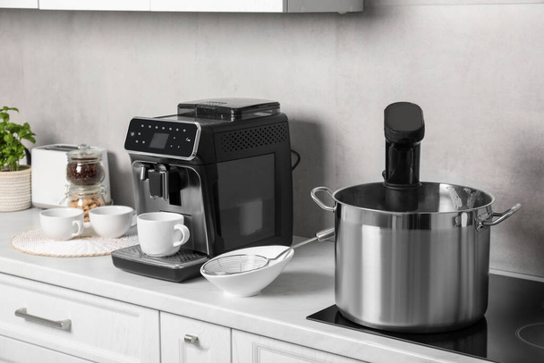 Pot with sous vide cooker in kitchen. Thermal immersion circulator - Foto, imagen