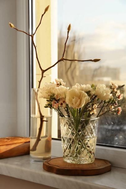 Beautiful spring flowers in vase on windowsill indoors - Foto, imagen