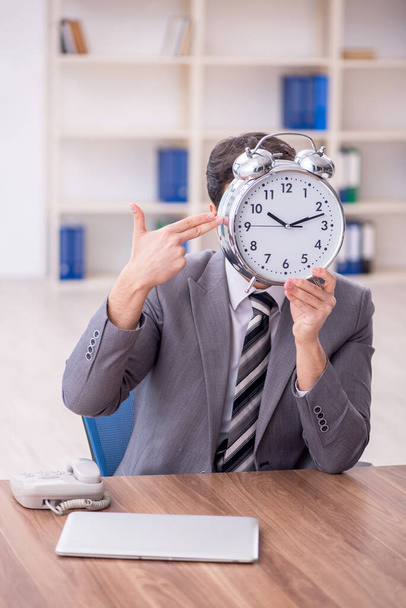 Young employee in time management concept - Foto, Imagen