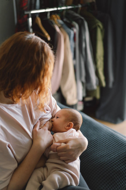 Newborn baby girl sucking milk from mothers breast. Portrait of mom and breastfeeding baby. Concept of healthy and natural baby breastfeeding nutrition. - Fotografie, Obrázek