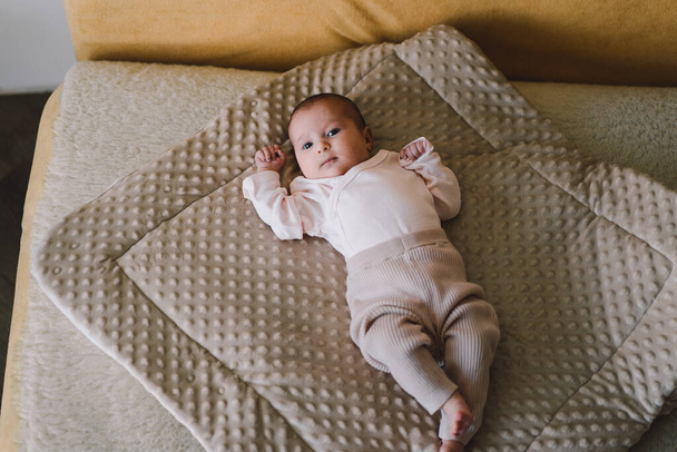 Portrait of a 1 month old baby. Cute newborn baby lying on a developing rug. Love baby. Newborn baby and mother. - Fotografie, Obrázek