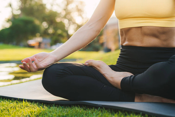 Close up portrait of caucasian sporty womans hands in sportswears relaxing, meditating on fitness mat in public park outdoors. Healthy active lifestyle - Foto, imagen