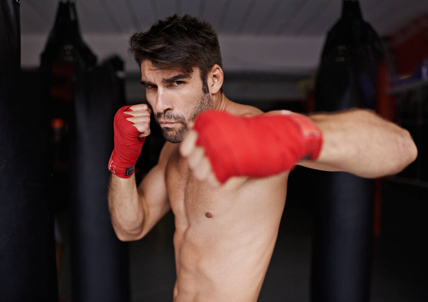 Scharfe Haltung. Porträt eines jungen Boxers in einem Fitnessstudio - Foto, Bild