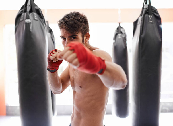 Připraven na souboj. Portrét mladého boxera v tělocvičně připraveného k boji - Fotografie, Obrázek