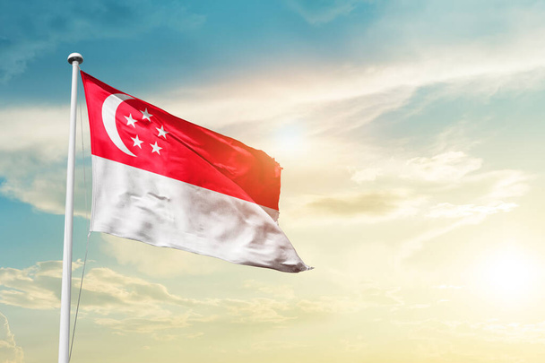 Σινγκαπούρη κυματίζει σημαία στον όμορφο ουρανό με ήλιο - Φωτογραφία, εικόνα
