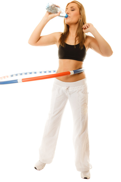Girl doing exercise with hula hoop. - 写真・画像