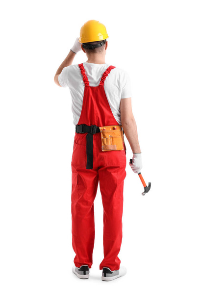 Young carpenter with hammer on white background, back view - 写真・画像