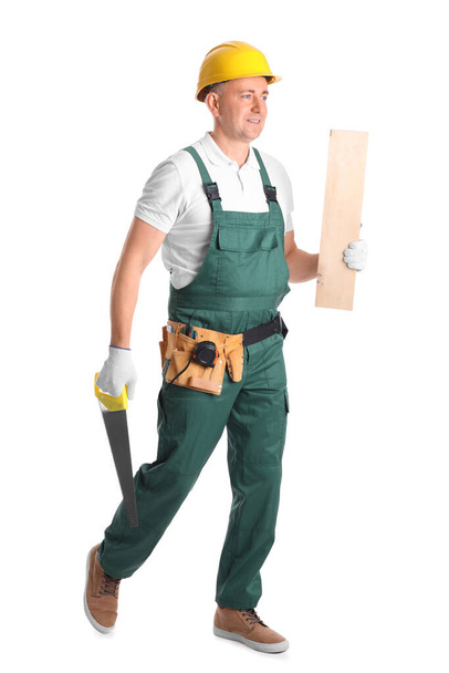 Mature carpenter with hacksaw and wooden plank on white background - Foto, immagini