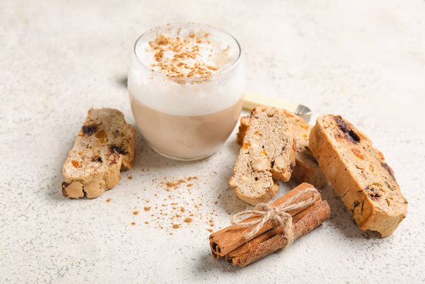 Finom biscotti cookie-k, fahéj és csésze kávé fehér grunge háttér - Fotó, kép