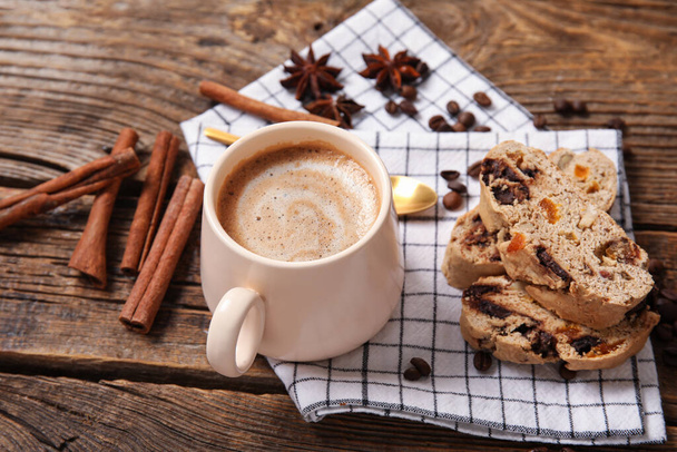 Finom biscotti cookie-k, fahéj, bab és csésze kávé fa alapon - Fotó, kép