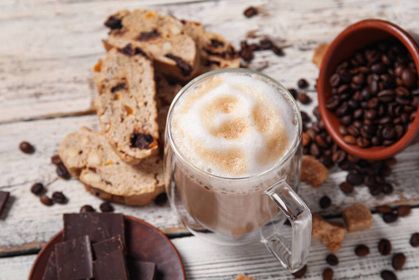 おいしいビスコッティクッキー、コーヒーカップ、チョコレートと白い木製の背景にコーヒー豆 - 写真・画像