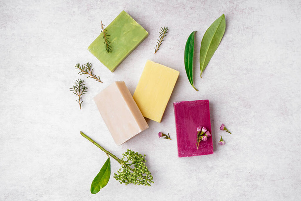 Composition with natural soap bars, plant leaves and flowers on light background - Photo, Image
