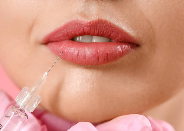 Young woman receiving filler injection in lips, closeup - Foto, Imagem