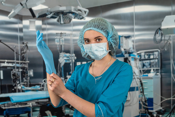 female doctor in the operating room in a special uniform injecting medicine through the patient. concepts of surgery. operating room medicine. doctor - Photo, Image