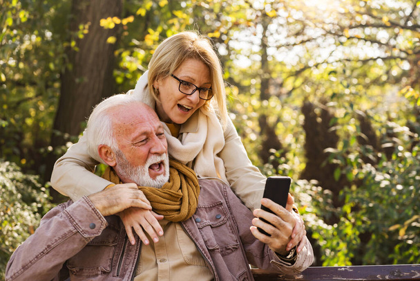para seniorów korzystających z telefonu w parku  - Zdjęcie, obraz