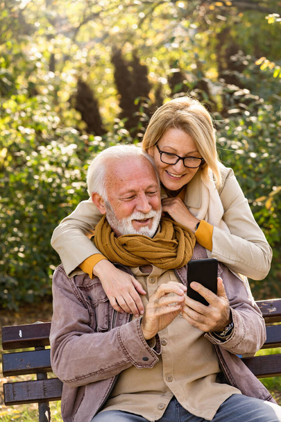 pareja de ancianos utilizando el teléfono en el parque  - Foto, Imagen