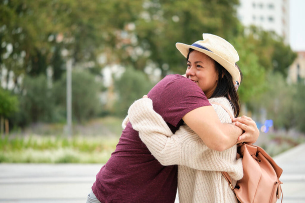 Happy multi-ethnic traveler couple smiling and hugging. Sightseeing in Madrid, Spain. - Fotografie, Obrázek