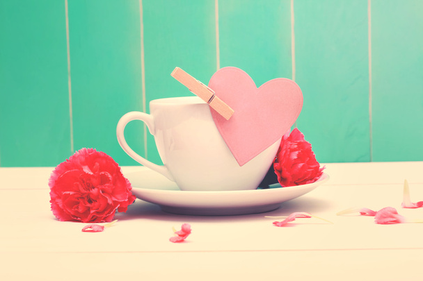 Coffee cup with pink heart tag and carnations - Photo, Image