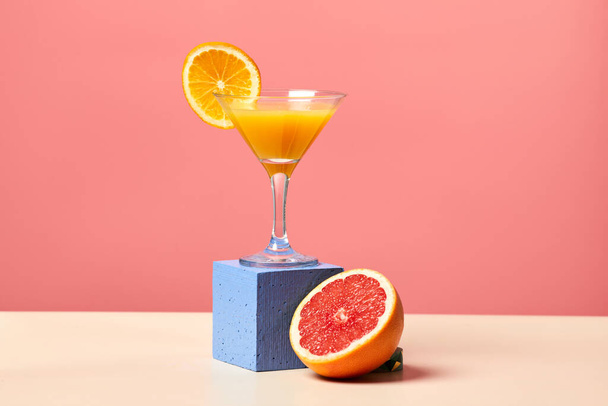 鮮やかなピンクの背景、ダイニングコンセプト、コピースペースに対するカクテルグラスで新鮮な柑橘類ジュースの最小ショット - 写真・画像