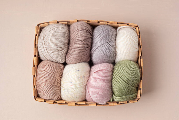 Craft knitting hobby background with yarn in natural colors. Recomforting hobby to reduce stress for cold fall and winter weather. Mock up, copy space, top view - Foto, Imagen