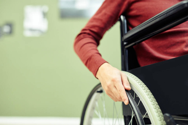 Primer plano de un joven irreconocible con discapacidad en silla de ruedas que visita la exposición de arte contemporáneo - Foto, imagen