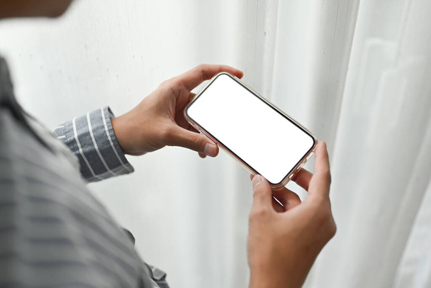 Close up view of man hands holding smart phone in horizontal position. Blank screen for your advertise text. - Φωτογραφία, εικόνα