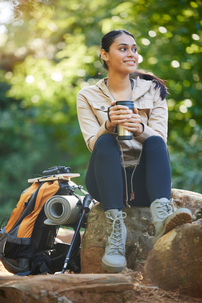 Hiking, woman and drinking coffee while on a backpacking break in the forest during a hike. Hiker, female and tea drink for freedom and carefree adventure in the woods for sport and active lifestyle. - Φωτογραφία, εικόνα