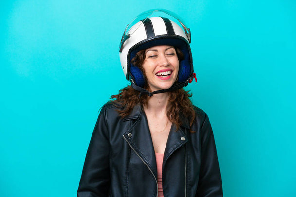 若いですcaucasian女性とともにオートバイヘルメット隔離上の青の背景笑い - 写真・画像