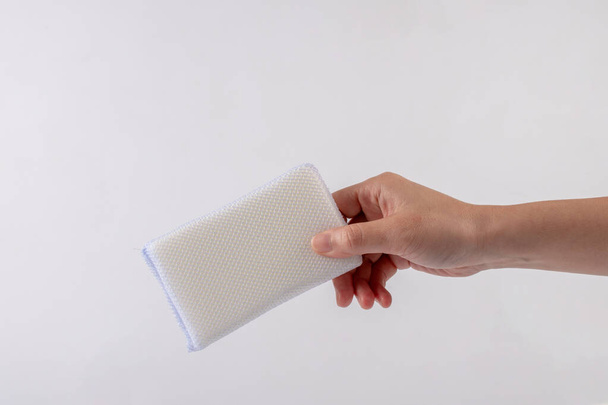 White sponge for washing dishes in hand on a white blackground. - Foto, immagini