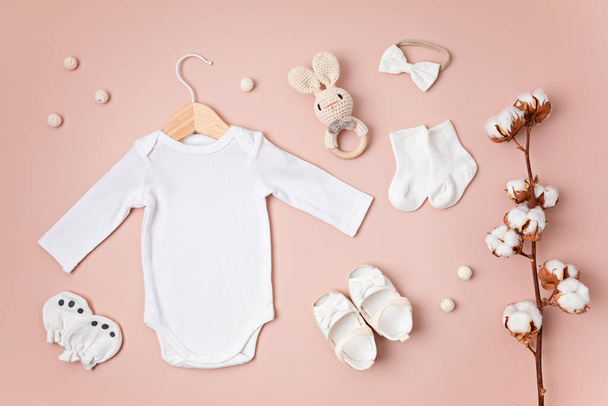 Mockup di body bianco per neonati in cotone biologico con accessori per bambini eco-compatibili. Modello Onesie per marchio, logo, pubblicità. Posa piatta, vista dall'alto - Foto, immagini