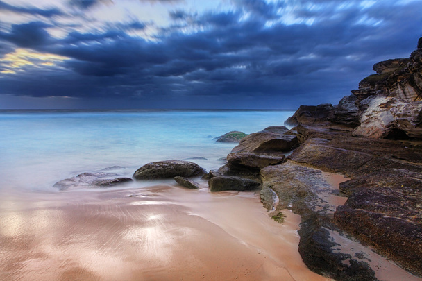 Praia deslumbrante e rochas costeiras antes do nascer do sol
 - Foto, Imagem