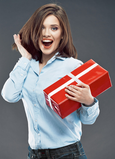 Surprised businesswoman holds red gift. - Foto, Imagen