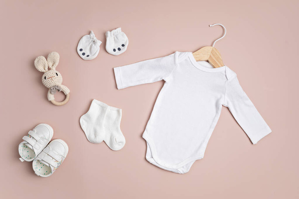 環境に優しい赤ちゃんのアクセサリーと有機綿で作られた白い幼児のボディスーツのモックアップ。ブランド、ロゴ、広告のためのワンセイテンプレート。フラットレイアウト、トップビュー - 写真・画像
